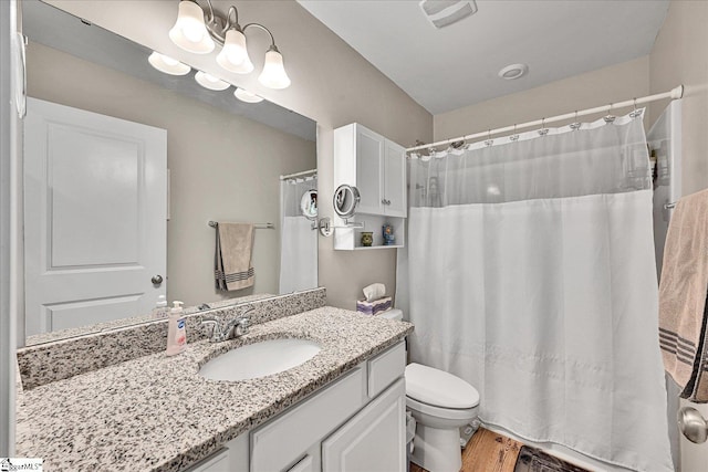 bathroom with wood finished floors, vanity, curtained shower, toilet, and visible vents