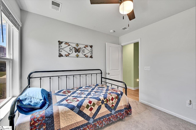 bedroom featuring baseboards, a ceiling fan, visible vents, and carpet