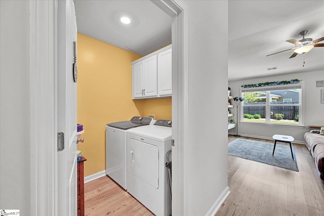 washroom with a ceiling fan, washing machine and dryer, baseboards, cabinet space, and light wood-style flooring