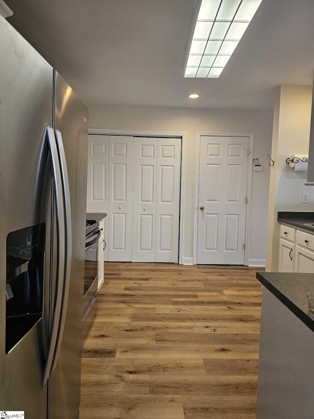 949 Jones Mill Rd, Fountain Inn, SC 29644 - kitchen with dark countertops, light wood finished floors, white cabinets, stainless steel refrigerator with ice dispenser, and recessed lighting