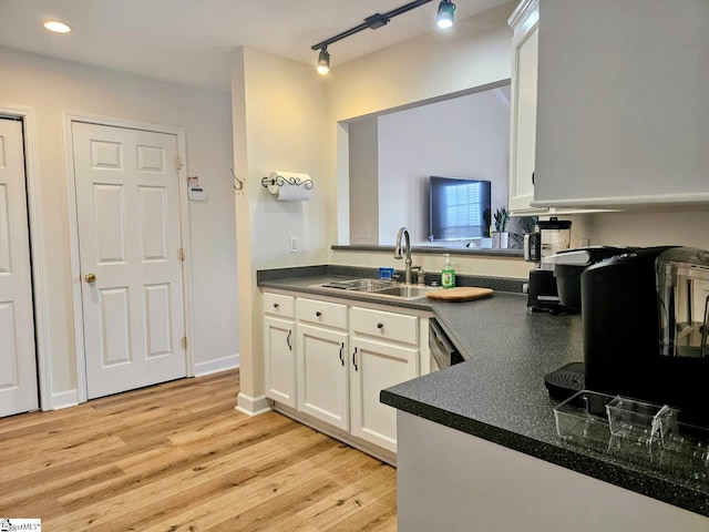 949 Jones Mill Rd, Fountain Inn, SC 29644 - kitchen with dark countertops, a sink, white cabinetry, and light wood-style flooring