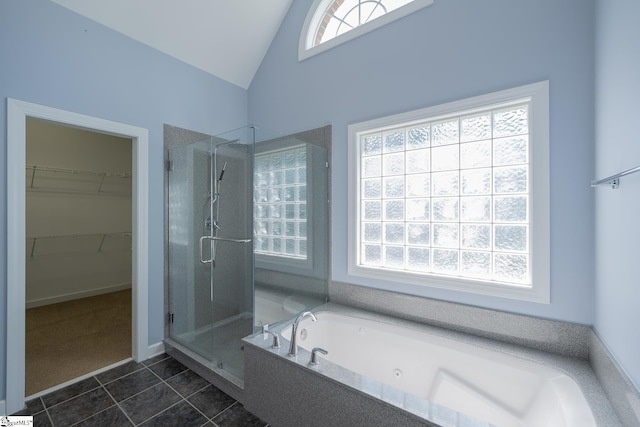 bathroom with vaulted ceiling, a tub with jets, tile patterned floors, a stall shower, and a spacious closet