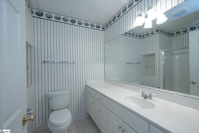 bathroom featuring tile patterned floors, visible vents, toilet, vanity, and walk in shower