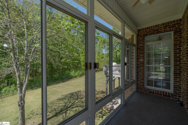 unfurnished sunroom with ceiling fan