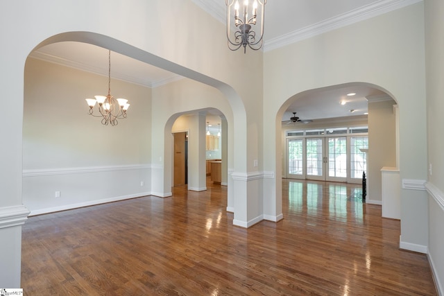 spare room with ornamental molding, baseboards, dark wood-style flooring, and ceiling fan with notable chandelier