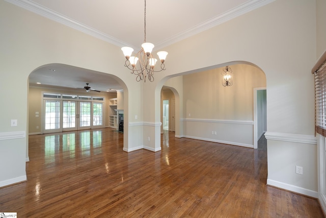 interior space with baseboards, wood finished floors, ceiling fan, and crown molding