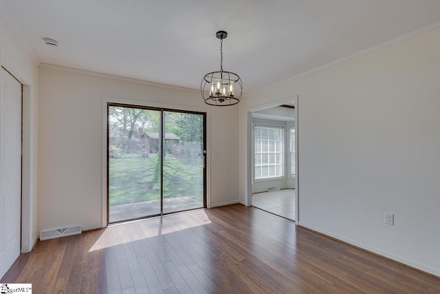 empty room featuring visible vents, baseboards, a notable chandelier, wood finished floors, and crown molding