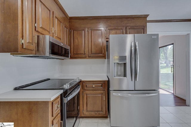 kitchen with stainless steel appliances, light countertops, and light tile patterned floors