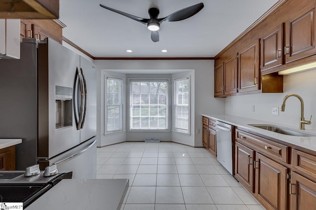 kitchen with a ceiling fan, a sink, appliances with stainless steel finishes, and crown molding
