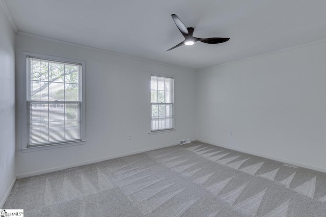 empty room featuring crown molding, carpet flooring, and plenty of natural light