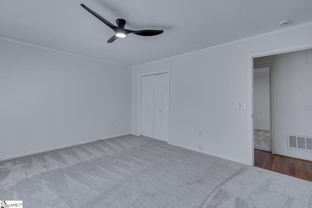 unfurnished bedroom with carpet, visible vents, crown molding, and baseboards