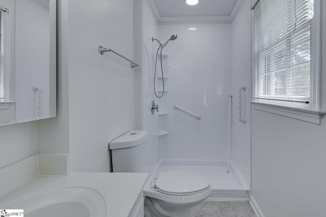bathroom featuring toilet, vanity, ornamental molding, baseboards, and a stall shower