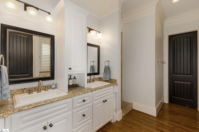 full bathroom featuring crown molding, wood finished floors, baseboards, and double vanity
