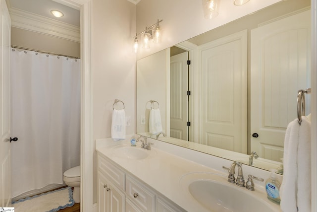 full bath with toilet, double vanity, and crown molding