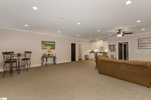 living area with recessed lighting, ornamental molding, light carpet, baseboards, and a ceiling fan