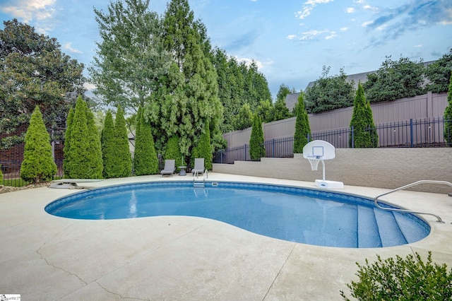 view of swimming pool with fence and a patio area