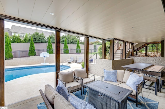 view of pool featuring an outdoor living space, stairway, a patio, and fence