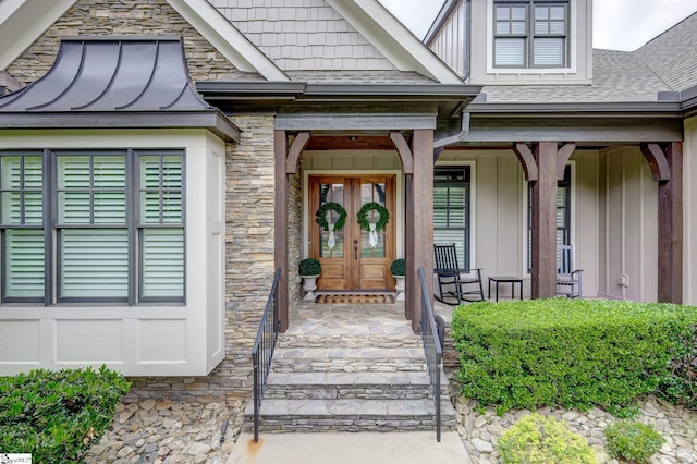 doorway to property featuring board and batten siding, french doors, a porch, and roof with shingles