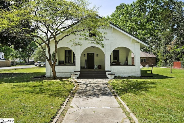 501 N Adair St, Clinton, SC 29325 - view of front of home featuring brick siding, fence, a porch, and a front yard