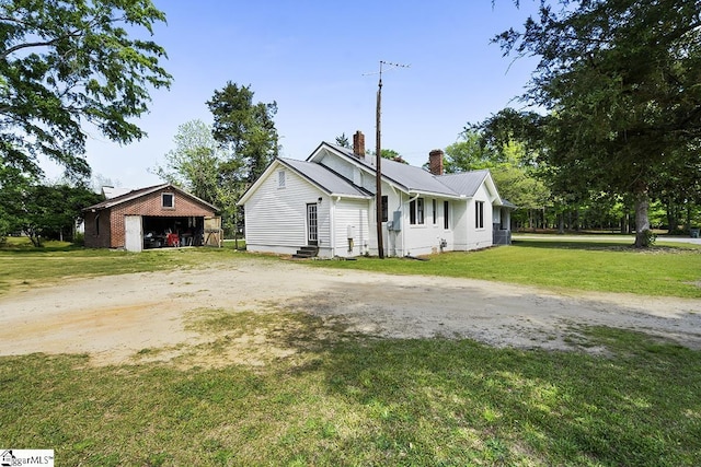 501 N Adair St, Clinton, SC 29325 - view of front facade with a chimney, metal roof, entry steps, an outdoor structure, and a front yard