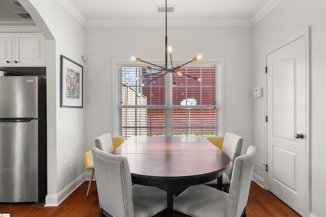 504 Anderson St, Greenville, SC 29601 - dining area with a notable chandelier, visible vents, ornamental molding, baseboards, and dark wood-style flooring