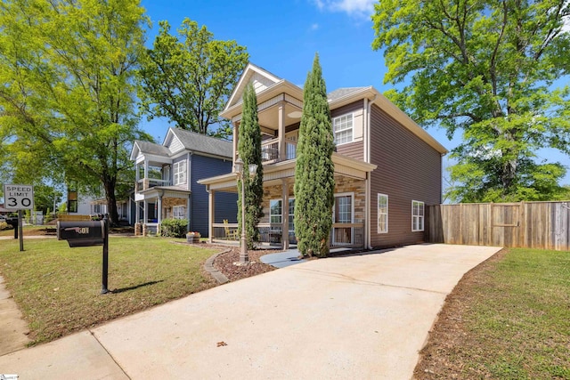 504 Anderson St, Greenville, SC 29601 - traditional-style house with fence, a balcony, driveway, stone siding, and a front yard