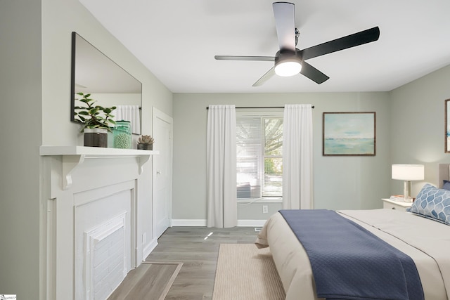 bedroom with wood finished floors, baseboards, and ceiling fan