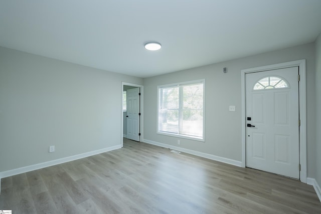 foyer entrance with wood finished floors, a wealth of natural light, baseboards, and visible vents