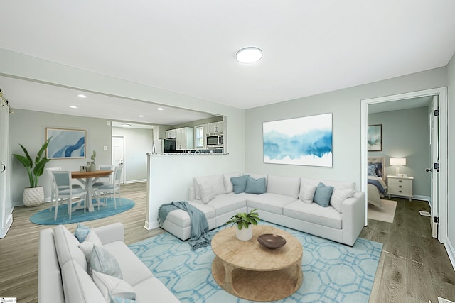 living area with recessed lighting, light wood finished floors, and baseboards