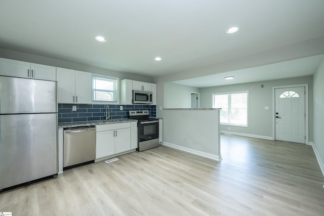 kitchen featuring light wood-type flooring, stainless steel appliances, and white cabinetry