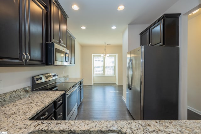 kitchen featuring recessed lighting, light stone counters, baseboards, appliances with stainless steel finishes, and dark wood-style flooring