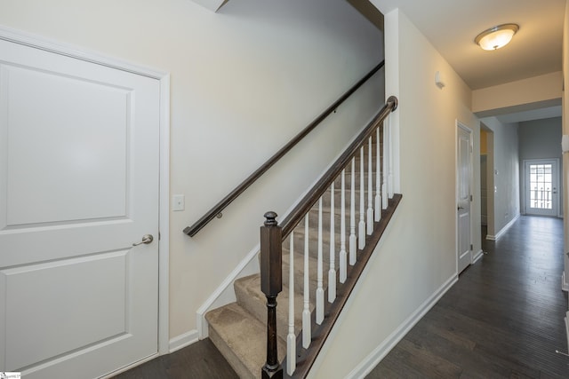 staircase featuring baseboards and wood finished floors