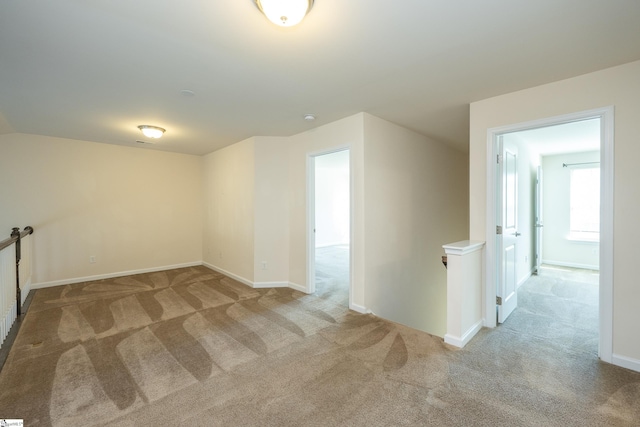 interior space featuring light colored carpet and baseboards