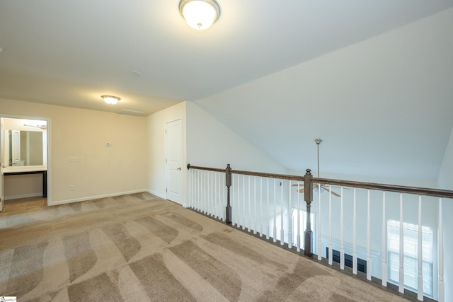 bonus room with lofted ceiling and light carpet