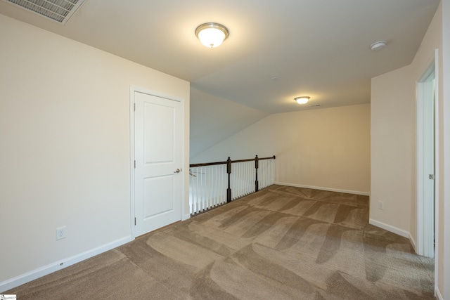additional living space with vaulted ceiling, carpet, visible vents, and baseboards