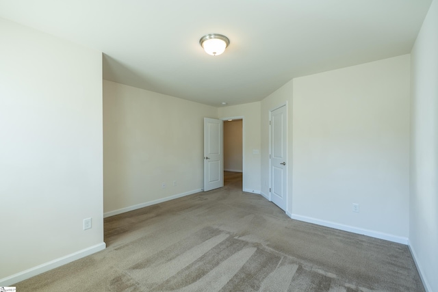 unfurnished bedroom with light carpet and baseboards