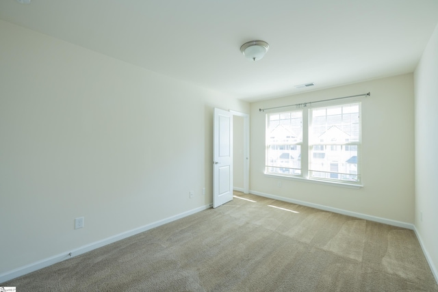 spare room featuring baseboards, carpet flooring, and visible vents