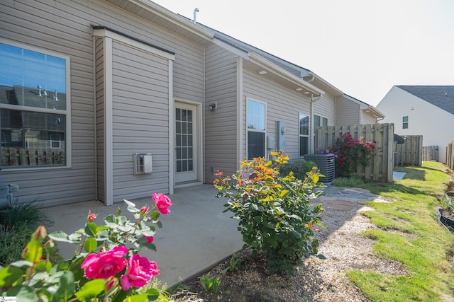 view of property exterior featuring fence, a patio area, and central AC unit
