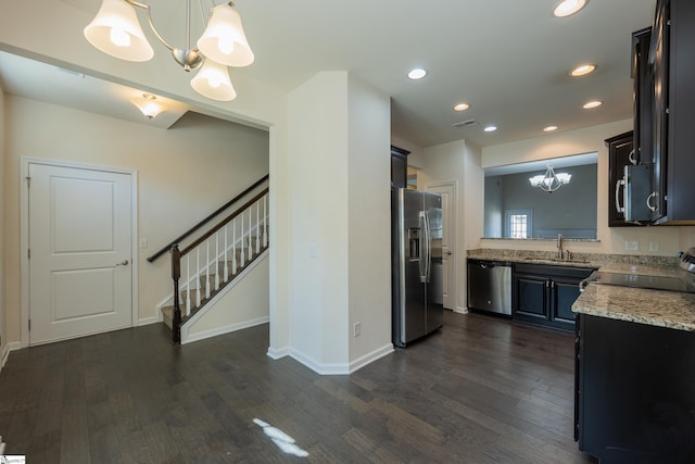kitchen featuring dark wood finished floors, a notable chandelier, stainless steel appliances, and a sink