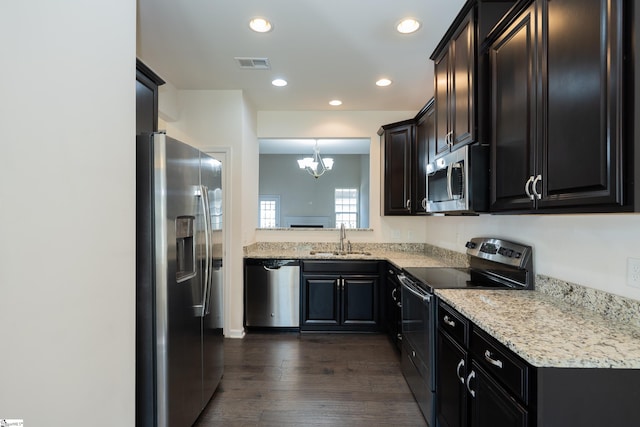 kitchen with dark wood-style floors, stainless steel appliances, visible vents, a sink, and a chandelier