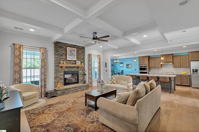 living area with light wood-style floors, visible vents, ornamental molding, and coffered ceiling