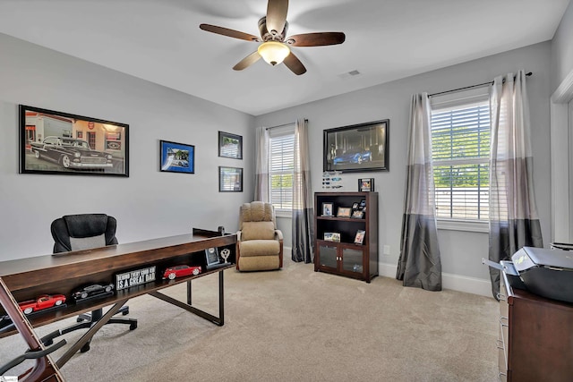 home office featuring a ceiling fan, carpet flooring, visible vents, and plenty of natural light