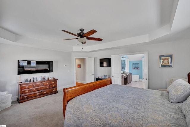 bedroom with ceiling fan, baseboards, carpet flooring, and a raised ceiling