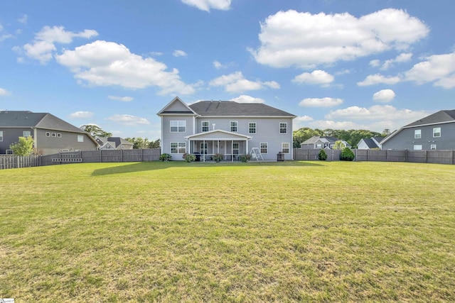 rear view of property with a lawn and a fenced backyard