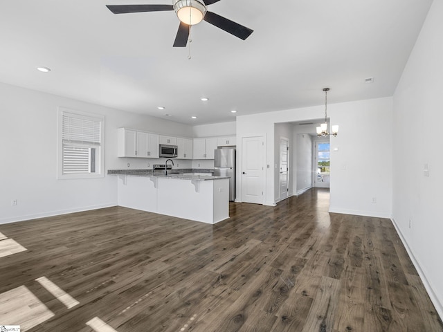 1415 Darrowby Way, Spartanburg, SC 29301 - kitchen featuring a sink, dark wood-type flooring, a peninsula, appliances with stainless steel finishes, and a breakfast bar area