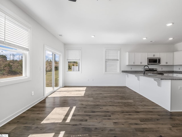 1415 Darrowby Way, Spartanburg, SC 29301 - kitchen with a kitchen breakfast bar, stainless steel appliances, baseboards, white cabinetry, and recessed lighting