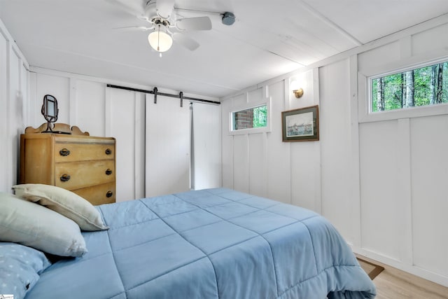 1506 W Lakeshore Dr, Landrum, SC 29356 - bedroom with light wood-style floors, a barn door, and a decorative wall