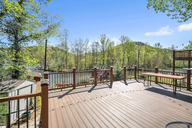 1506 W Lakeshore Dr, Landrum, SC 29356 - wooden deck featuring an outdoor structure, a storage unit, and a water and mountain view