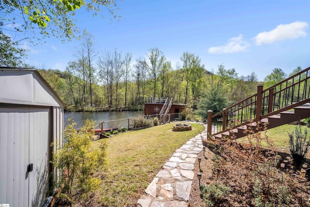 1506 W Lakeshore Dr, Landrum, SC 29356 - view of yard featuring a storage unit, a water view, a fire pit, stairs, and an outdoor structure