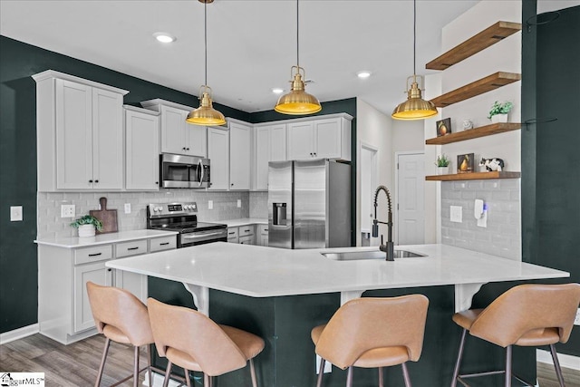 633 Morning Meadows Dr, Inman, SC 29349 - kitchen with a breakfast bar, wood finished floors, a sink, tasteful backsplash, and appliances with stainless steel finishes